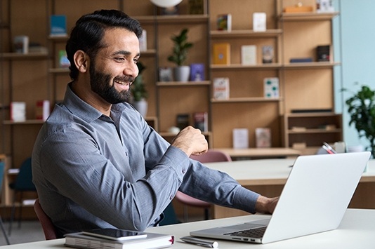 Happy professional working at laptop