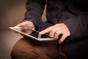 A closeup of a man on his tablet.