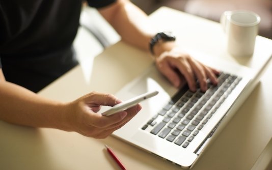 man-using-phone-laptop