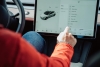 A person in their car using its large touchscreen monitor.