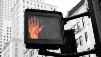 Red hand on a street stop sign